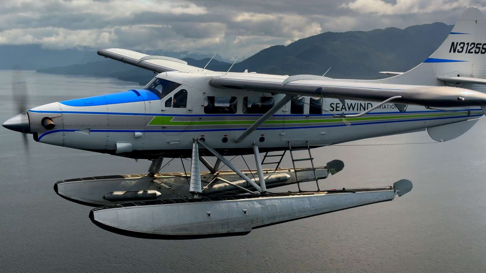 SeaWind Aviation floatplane flying over Southeast Alaska water and mountains